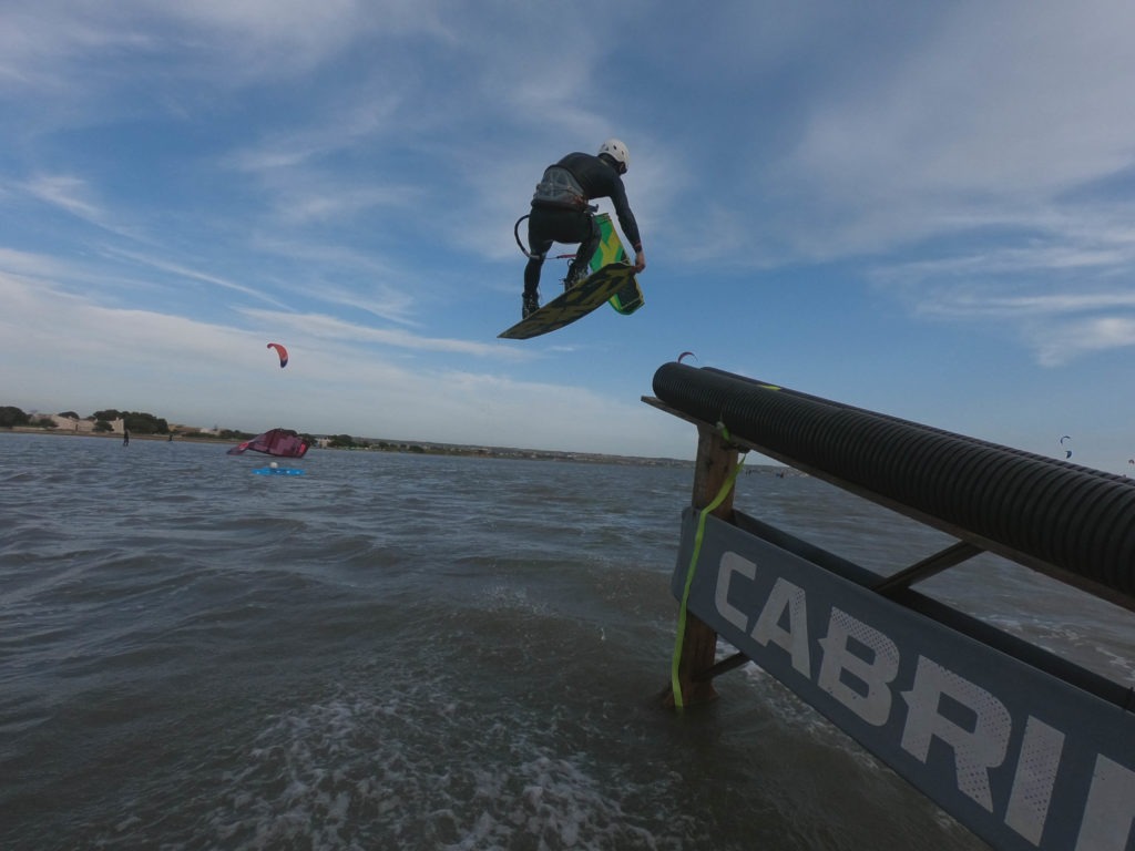 kiteboarder riding a slider in Sicily flatwater Italy features world class kiteboard academy grab