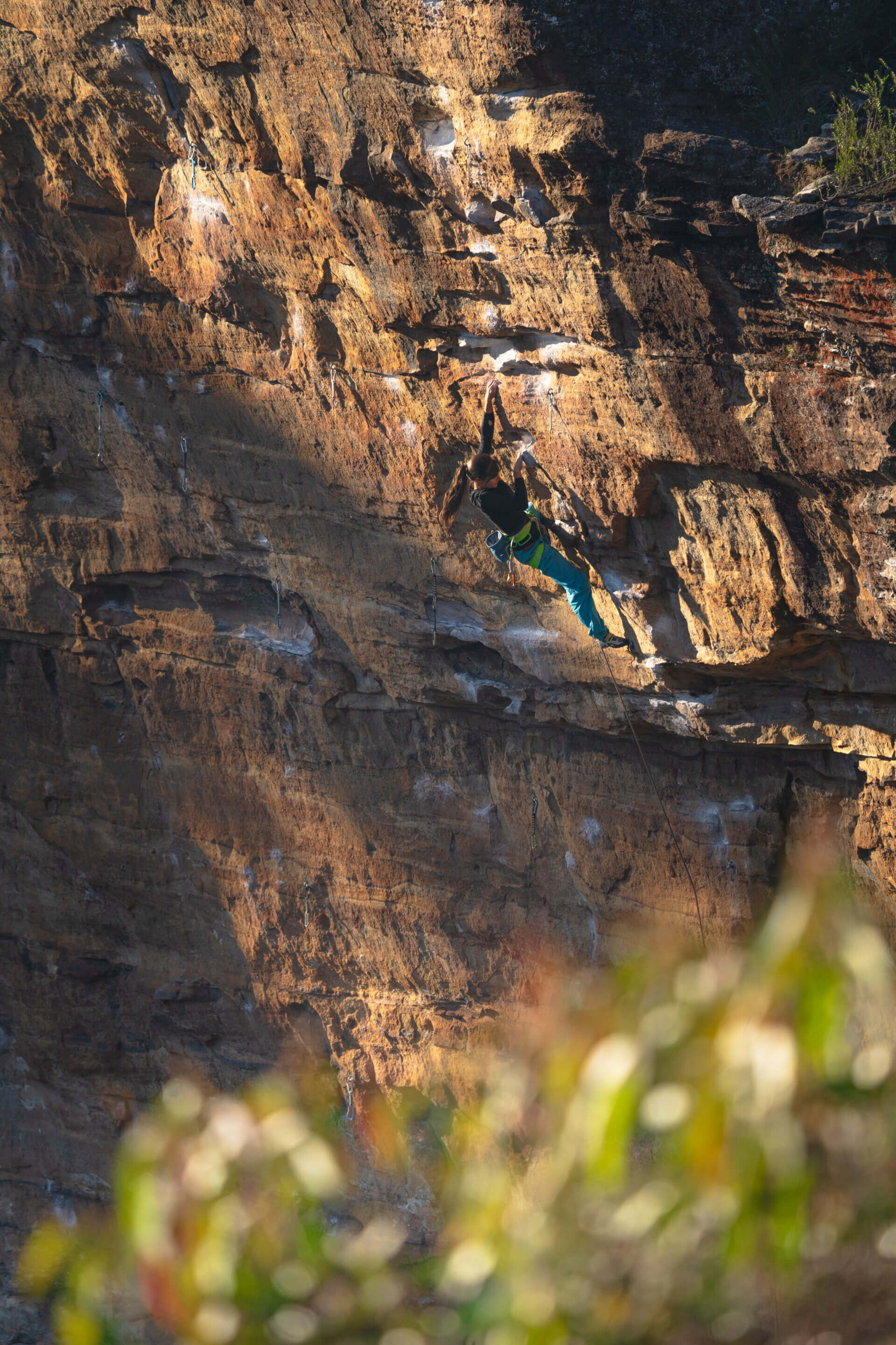 Climber on a sandstone cliff in warm golden light in the Blue Mountains, Australia