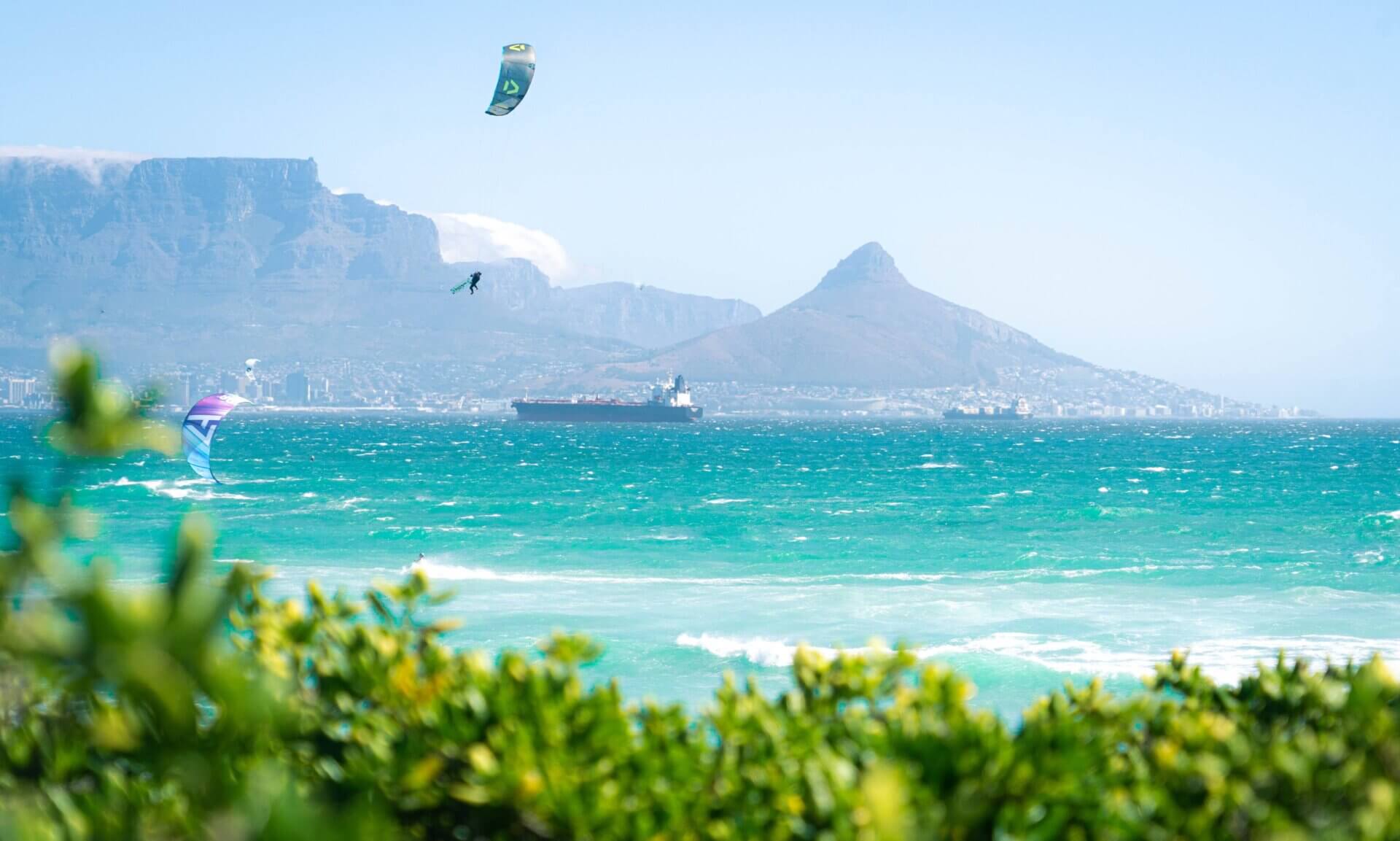 Kiteboarder riding on turquoise water with Table Mountain and Lion's Head in the background, Cape Town, South Africa