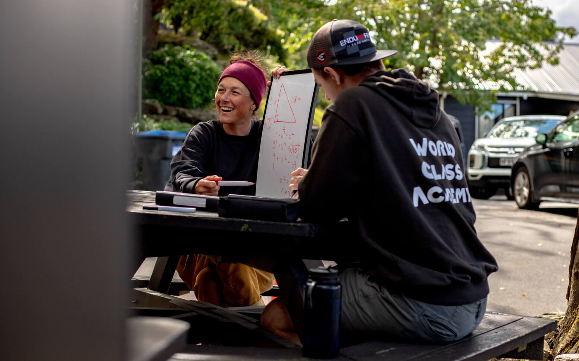 Teacher smiling and teaching student at a picnic table