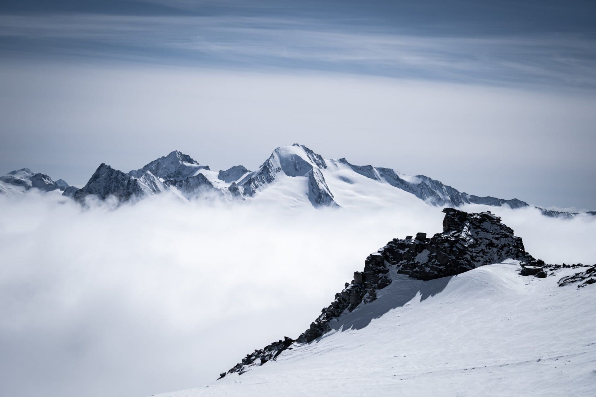 Snow-covered peaks rising above a sea of clouds