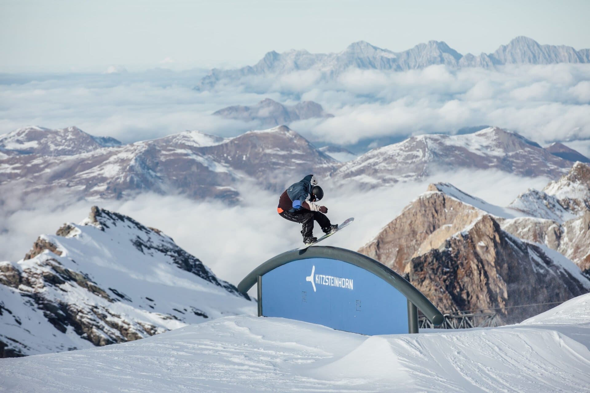 Snow Sports hero: snowboarder on an arch rail above the clouds
